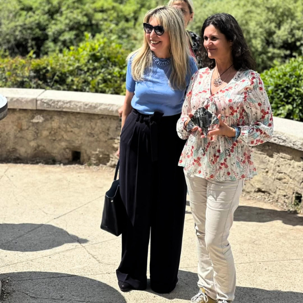 Deux femmes de face, l'une porte une statuette représentant le prix littéraire Cap de Lire 2025 du Salon du livre de Antibes